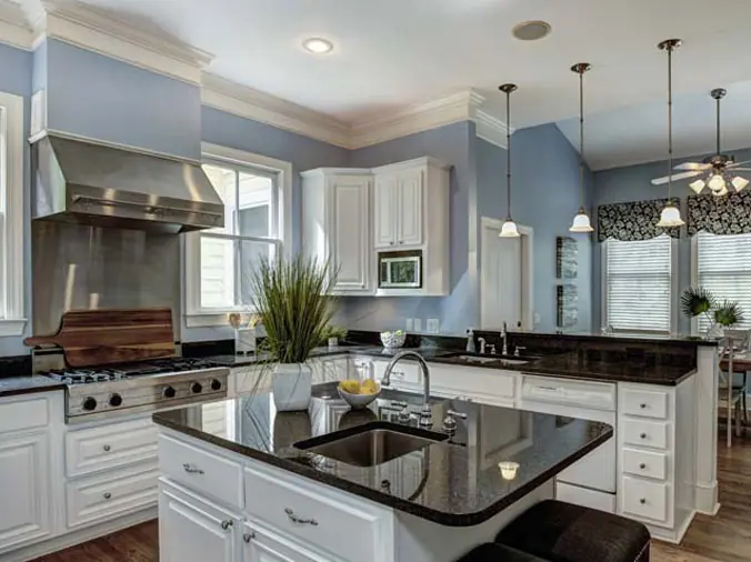 Kitchen with blac stone counters and stainless appliances and fixtures